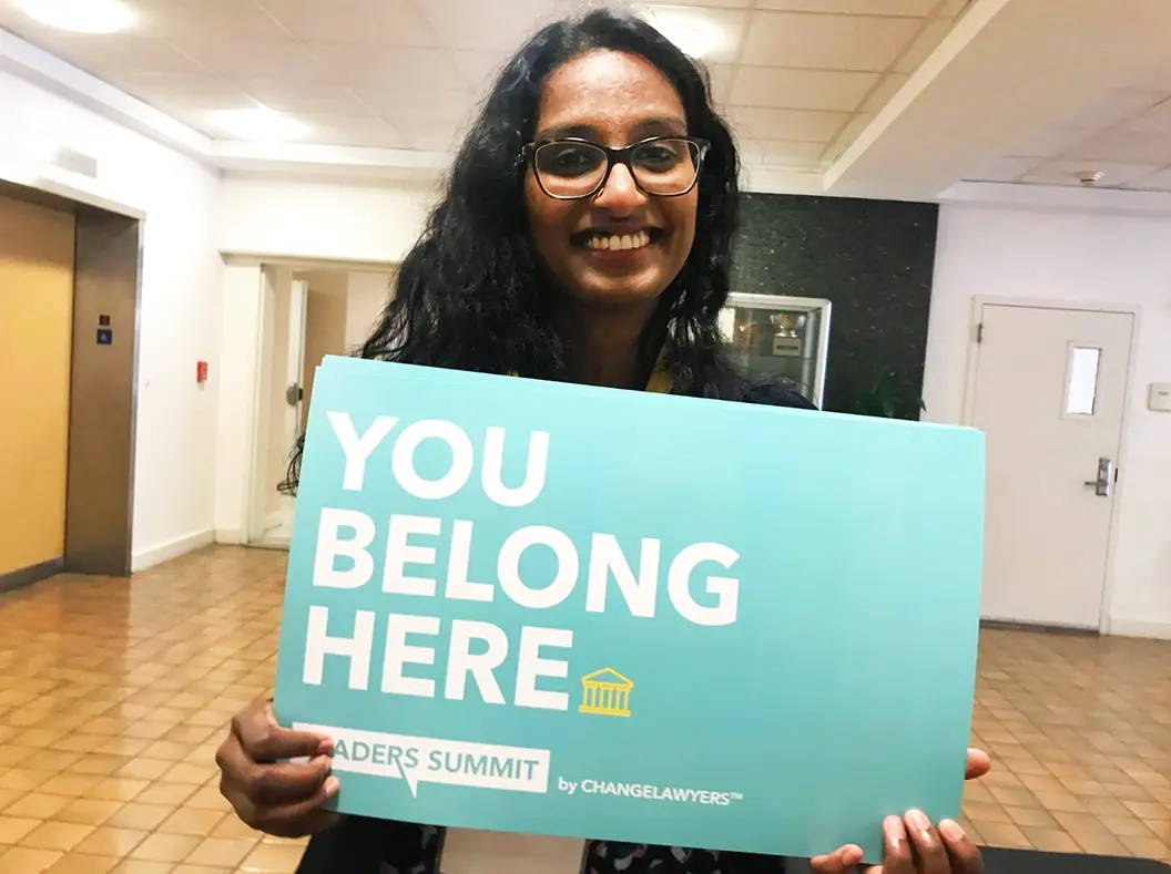 Mission Minded team member holding a 'You Belong Here' sign at a leadership event