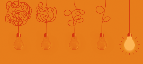 This image shows 5 light bulbs hanging. All but one have cords that are tangled. The one that isn't is lit, communicating that simple (non complex) ideas spark creativity.